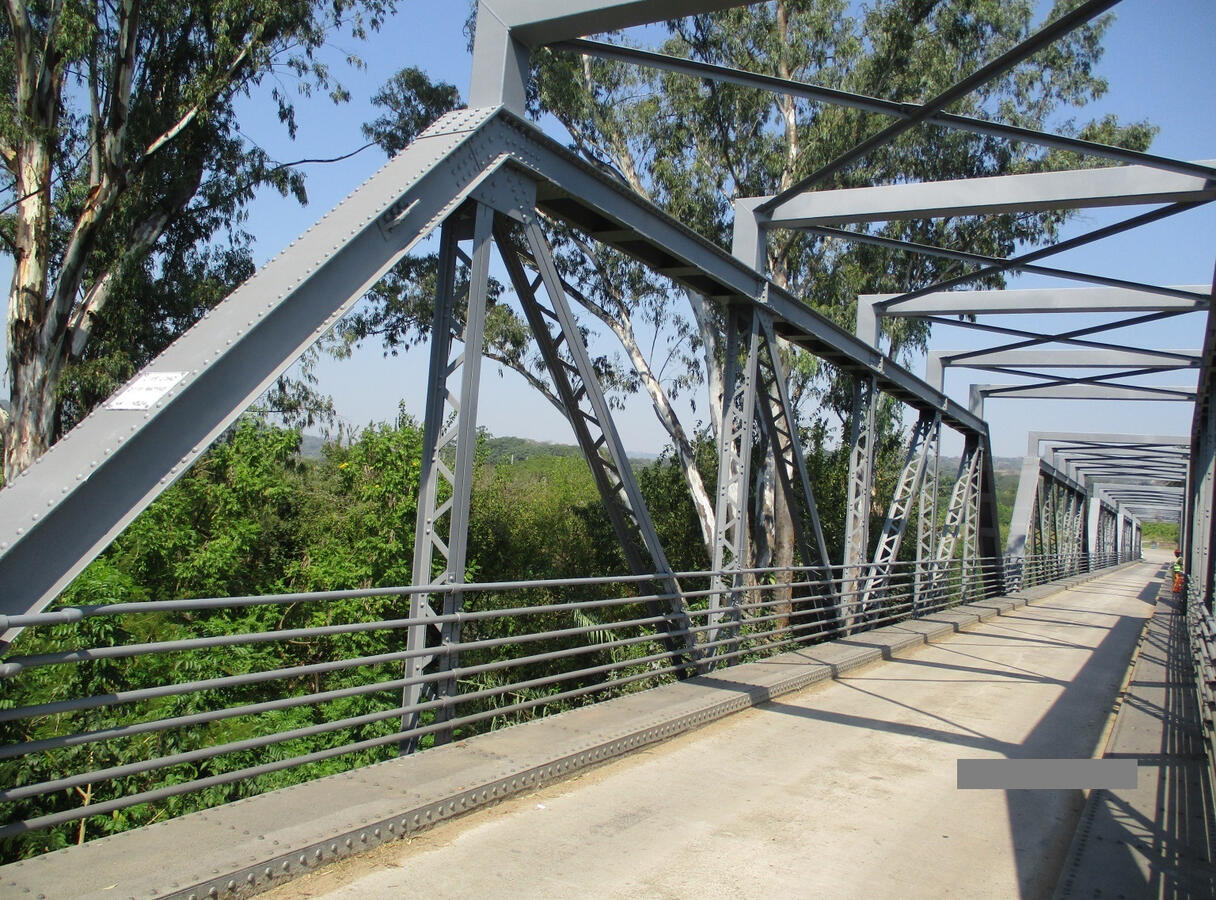 Steel Bridges Steel pedestrian bridge with triangular bracing and handrails.