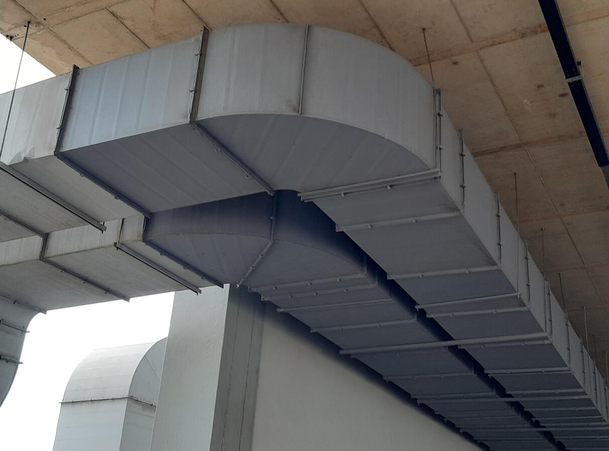 Industrial Ventilation Rectangular ventilation ductwork suspended beneath a concrete ceiling.