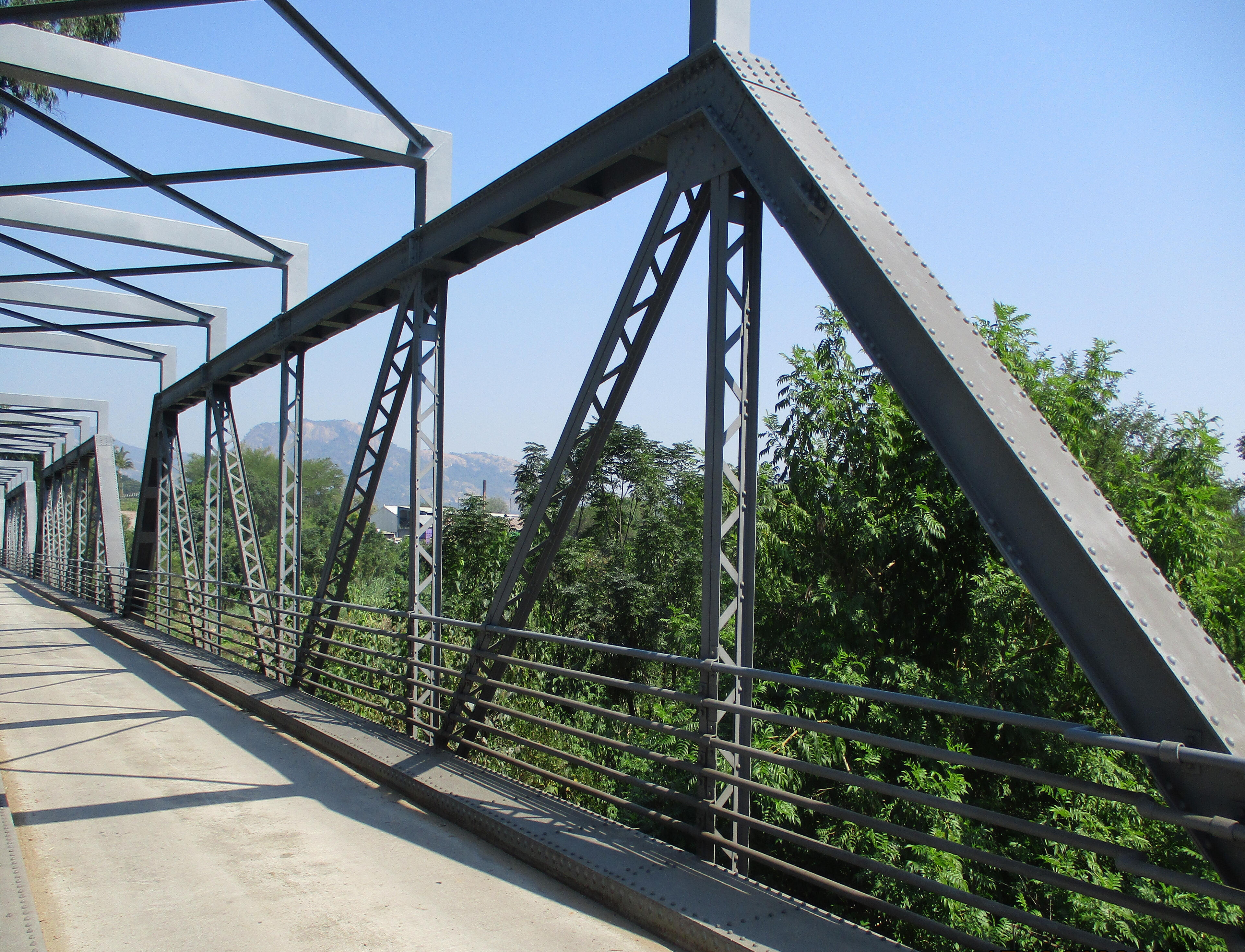 Riveted steel truss bridge with grey-coated beams